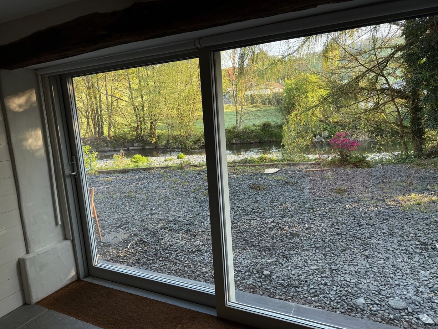 The river and the field beyond, seen through the Mill’s full-height sliding window in spring